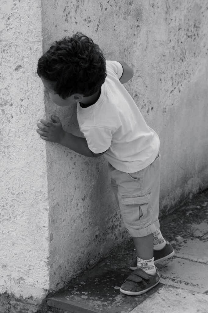 Dítě koukající zpoza rohu žijící na ulici