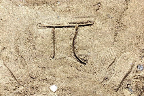 Matematický znak v písku.