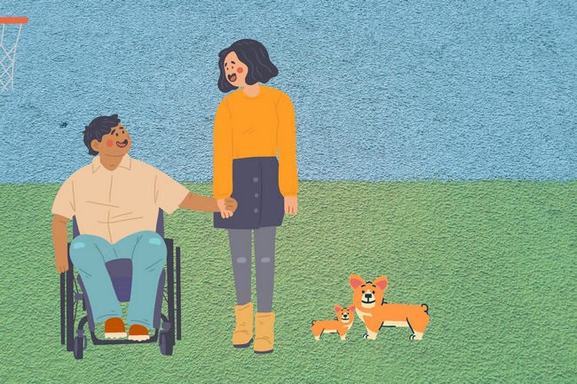 Muž na invalidním vozíčku drží za ruku ženu. Společně jsou venku a venčí psy.