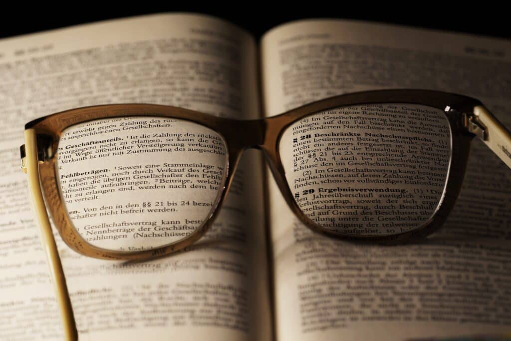 Zlaté brýle položené na knize zákona.
