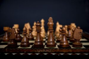 Šachovnice s rozestavenými figurkami v tmavé i světlé barvě