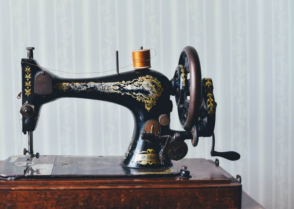 Starý šicí stroj se zlatými detaily.