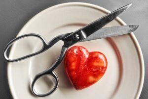 Červený kámen srdce s nůžkami na talíři
