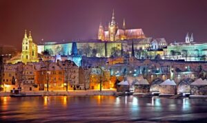 Praha vyfocená ve tmě osvětlená barevnými světly.