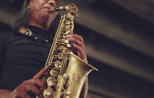 Jazzový hráč na saxofon. Pohled na klapky hudebního nástroje.