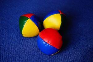 3 barevné míčky určené pro žonglování v červené, modré, zelené a žluté barvě.