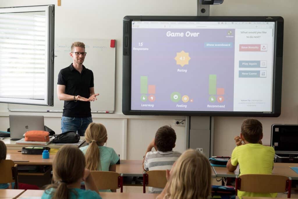 Profesor vyučuje děti pomocí digitální obrazovky.