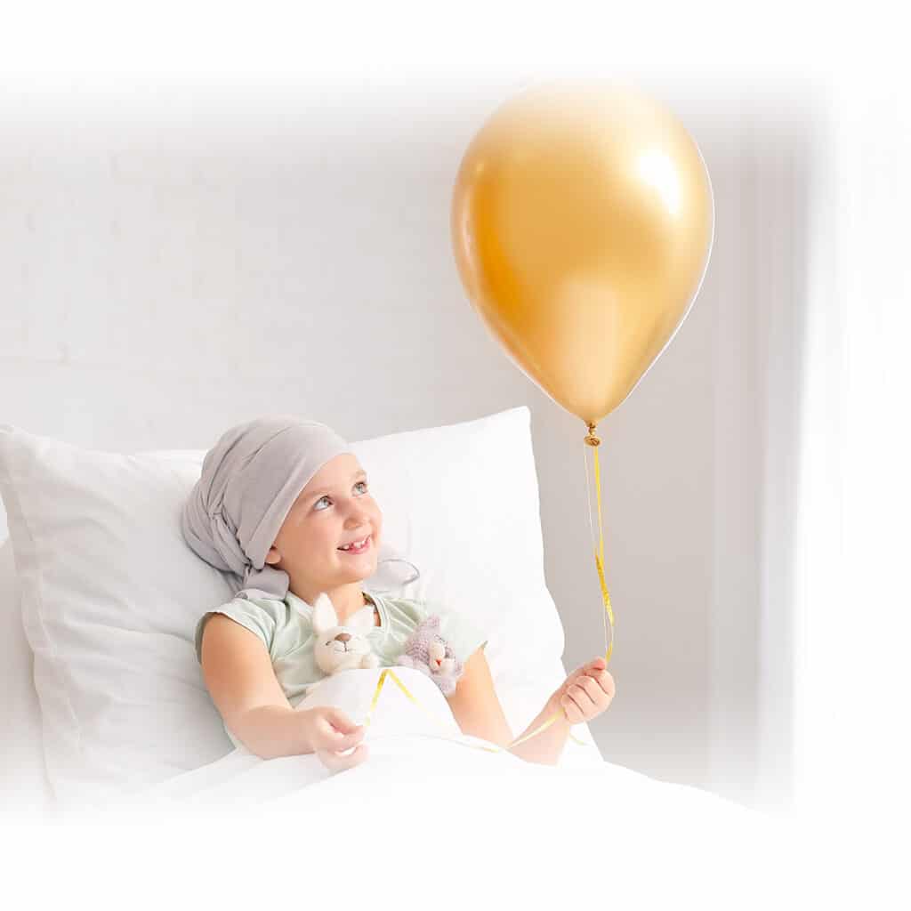 Děvčátko se zlatým balónkem v ruce.