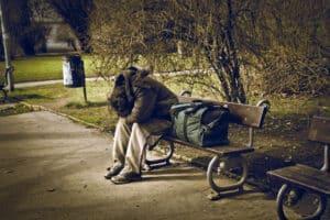 Muž bez domova na lavičce